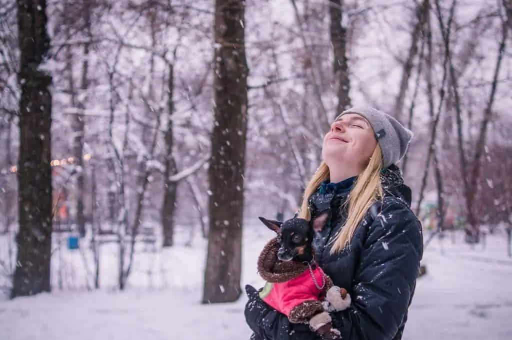 Pic 2 a woman holds her small dog in snow