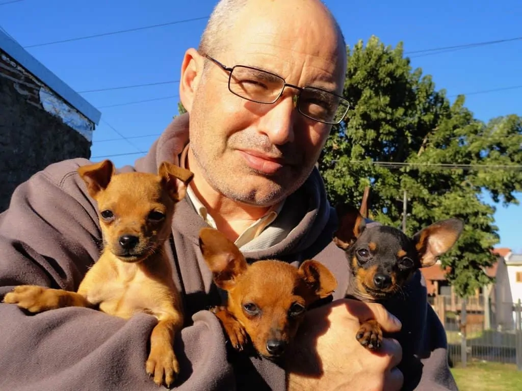 Pic 9 a man holds minpin puppies